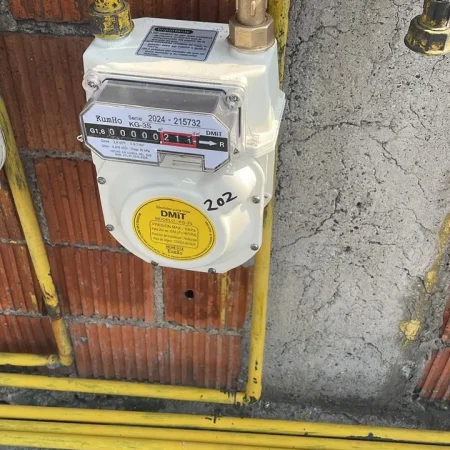 Medidor de gas Kumho instalado con conexiones en tubería amarilla, listo para monitoreo de consumo en edificio.