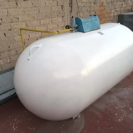 Tanque estacionario de gas pintado de blanco instalado en azotea con conexión de seguridad en color amarillo.